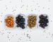 Variety of olives with spices in a white plates on white background, top view.