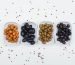 Variety of olives with spices in a white plates on white background, top view.